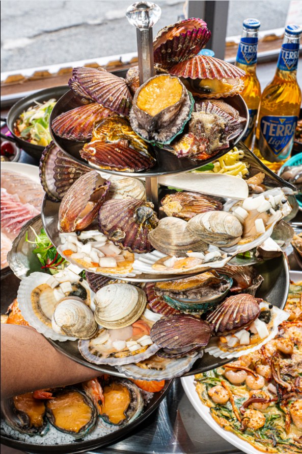 A tiered seafood assortment with scallops, clams and abalone.