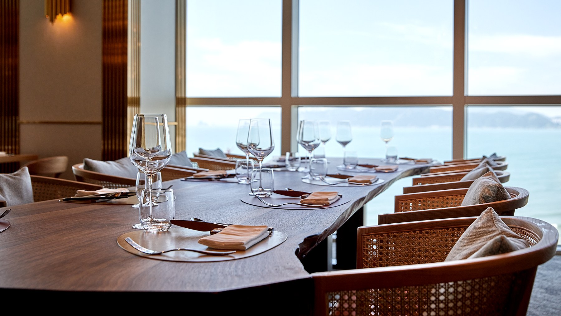 Window-side dining space overlooking the sea at The View on the fifth floor of SIGNIEL Busan. The official image file is dated August 2020, and the same room photograph remains in use in recent official Lotte Hotel materials.