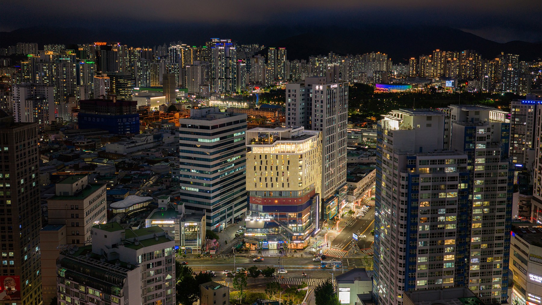 The illuminated Central Seven Hotel by Kwon building amid Seomyeon’s nighttime cityscape.
