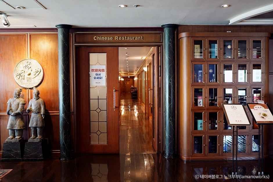 The interior entrance to Amisan, with wood paneling, display cabinets and menu stands.