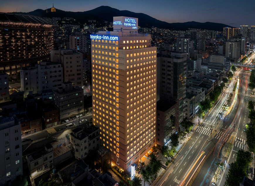 야간에 조명이 켜진 토요코인 부산중앙역 건물과 주변 도로.