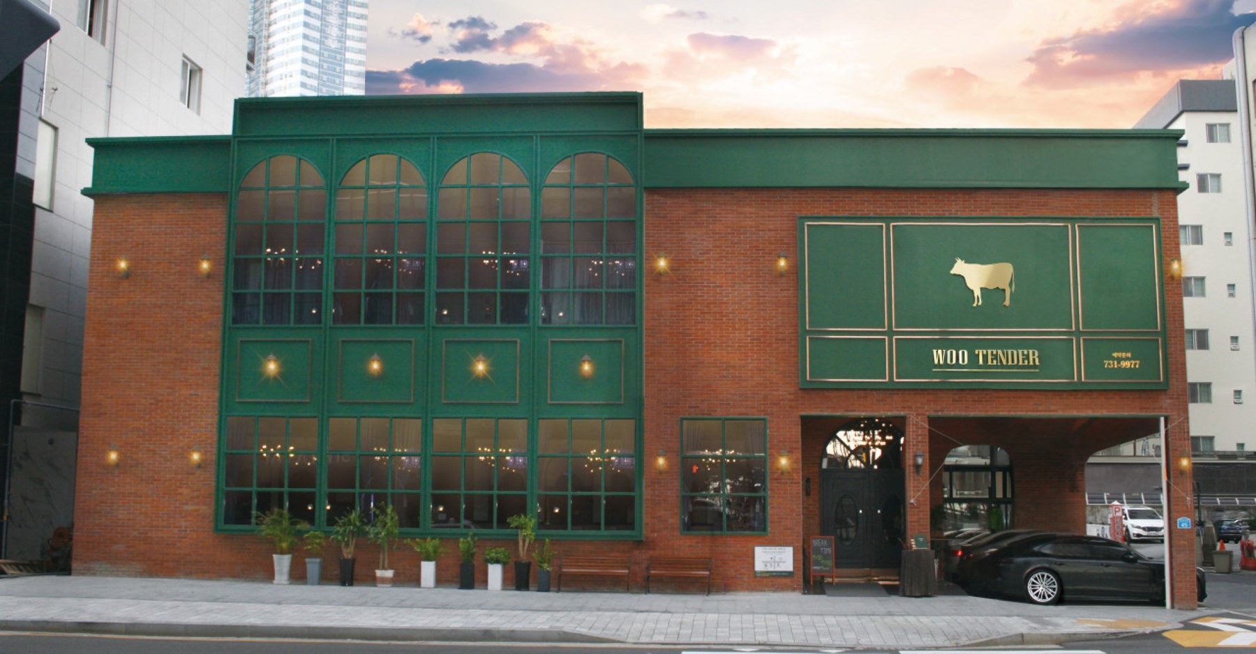 The red-brick exterior of Wootender Haeundae, with green arched windows and a visible “WOO TENDER” sign.