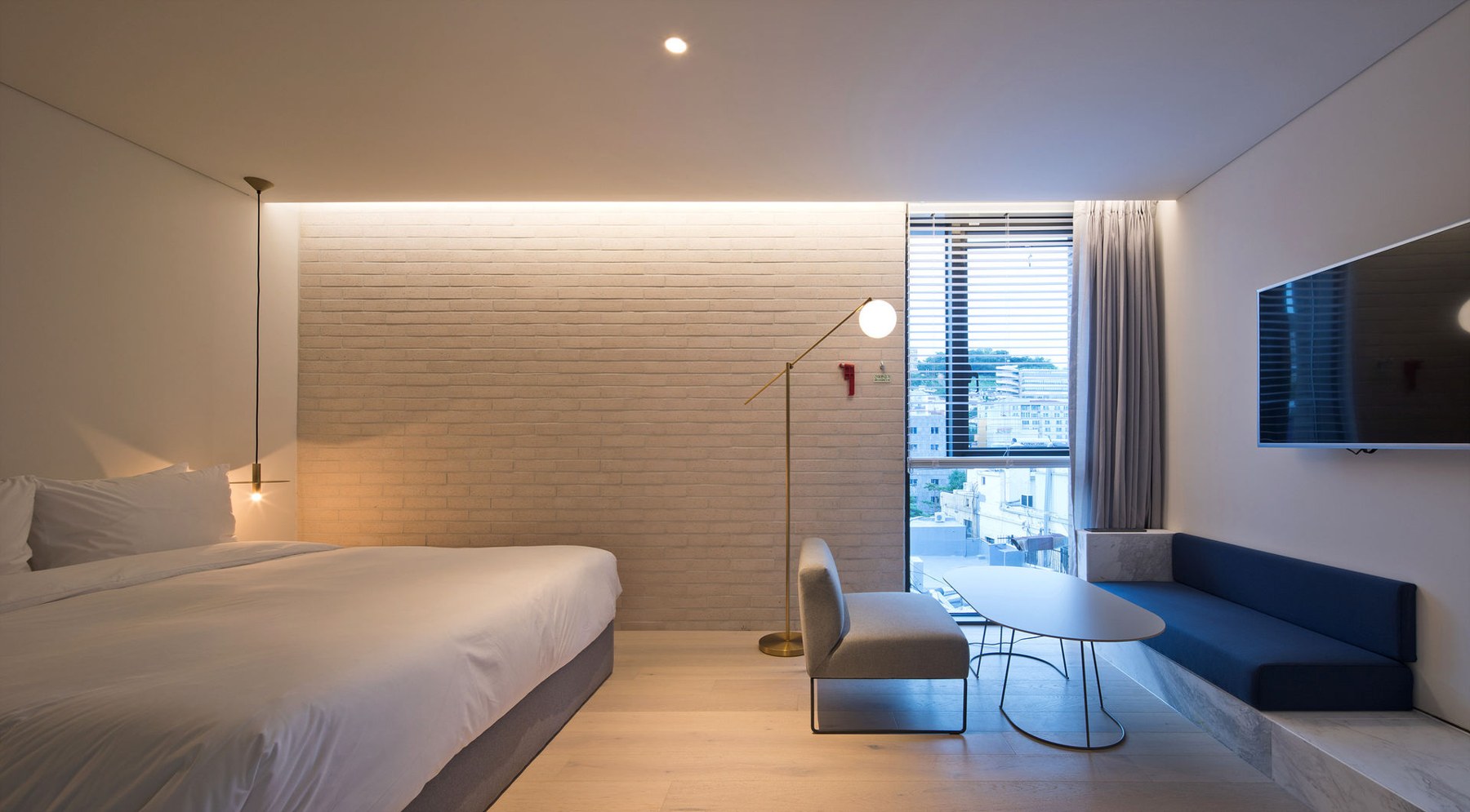 A Hotel CONT guest room with a double bed, wall bench, table and window. The capture date is unverified; the official image URL contains a September 17, 2017 path.